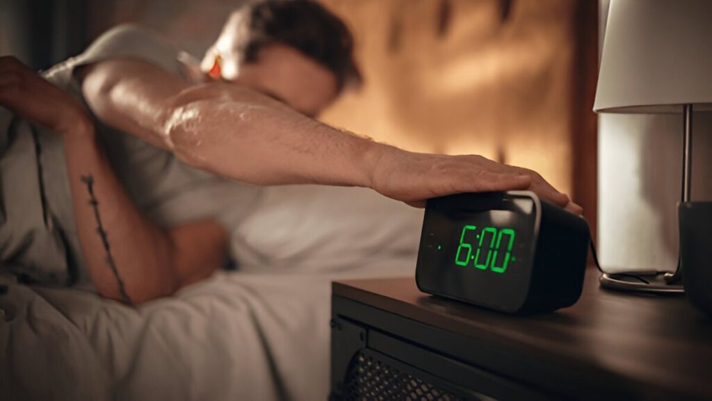 A man waking up early and an alarm clock, symbolizing the power of discipline over motivation.