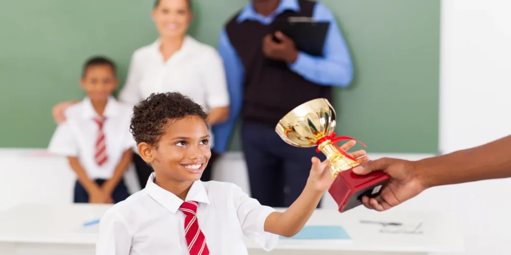 child receiving a gold star from a teacher 