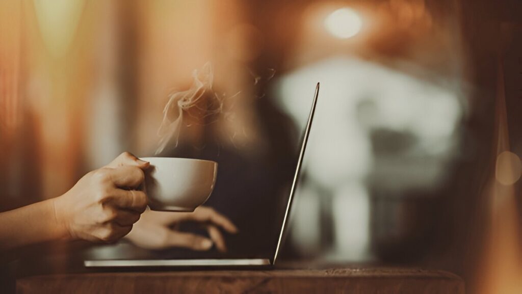 A person sitting at a desk with a cup of coffee, looking motivated and ready to tackle the day.